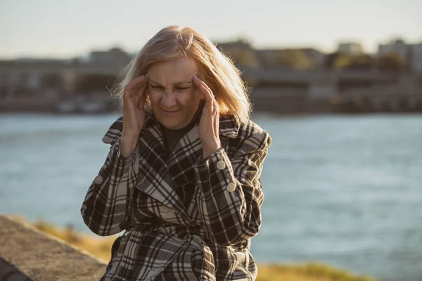 Senior Vrouw Hoofdpijn Hebben Tijdens Vergadering Door Rivier Getinte Afbeelding — Stockfoto