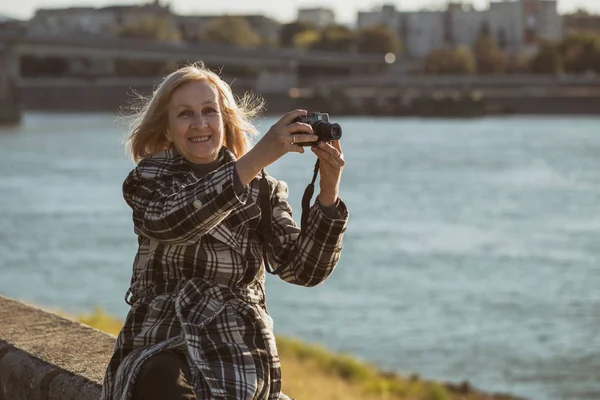 Mulher Sênior Gosta Fotografar Enquanto Está Sentado Junto Rio Imagem — Fotografia de Stock