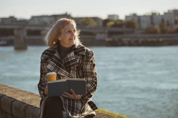 Mujer Mayor Disfruta Leyendo Libro Tomando Café Mientras Está Sentada —  Fotos de Stock