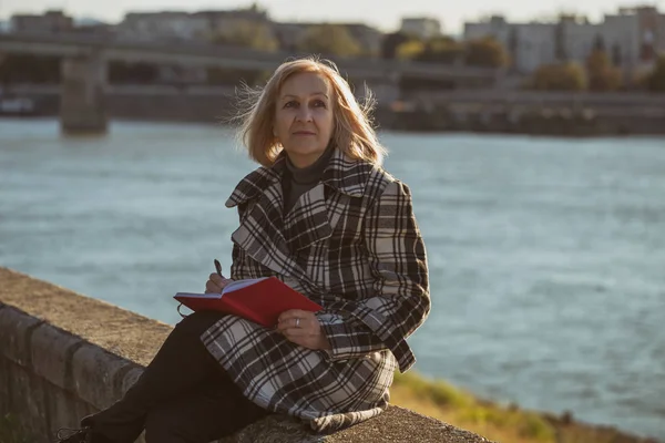 Senior Vrouw Geniet Van Schrijven Iets Zittend Door Rivier Getinte — Stockfoto