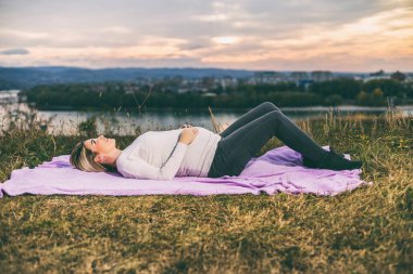 Güzel bir hamile kadın açık zaman geçirmekten hoşlanıyor. Tonlu görüntü.