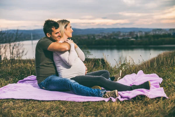 夫と妊娠中の妻と一緒に過ごす時間を楽しむ屋外 トーンのイメージ — ストック写真