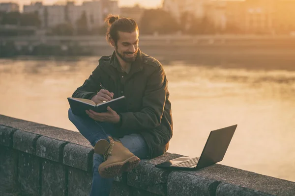 Schöner Geschäftsmann Mit Persönlichem Organisator Und Laptop Während Fluss Sitzt — Stockfoto