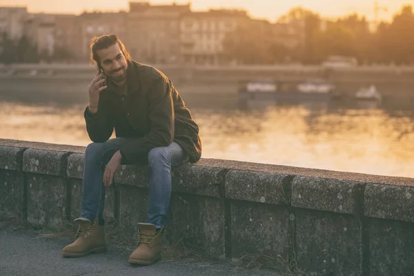 Snygg Modern Affärsman Med Telefonen Medan Sitter Vid Floden Tonad — Stockfoto