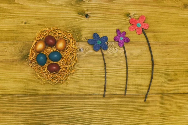 Βαμμένα Πασχαλινά Αυγά Άχυρο Λουλούδια Στο Ξύλινο Τραπέζι Τονισμένο Φωτογραφία — Φωτογραφία Αρχείου