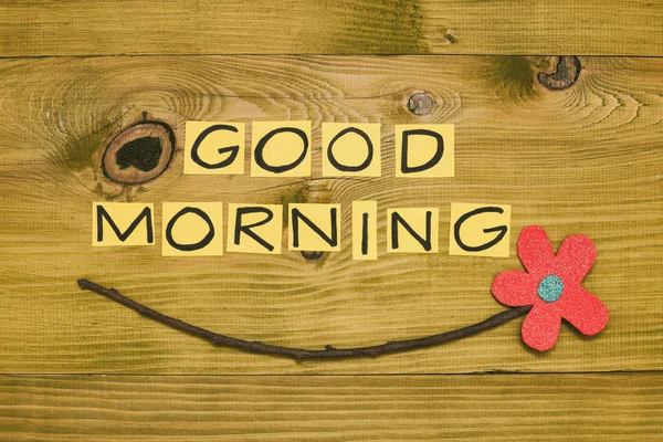 Image of text good morning and flower on wooden table.Toned photo.