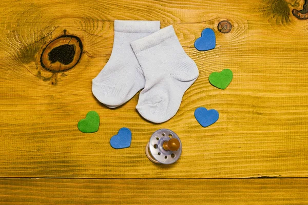 Little Blue Baby Boy Socks Pacifier Heart Shapes Wooden Table — Stock Photo, Image