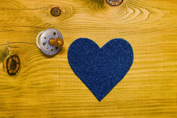 蓝色奶嘴为男婴与心脏形状在木桌上 婴儿公告概念 色调照片 — 图库照片