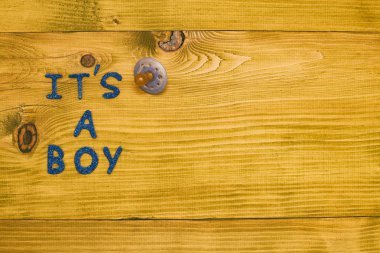 Metin, ahşap masada emzik olan bir çocuk. Tonlu fotoğraf.