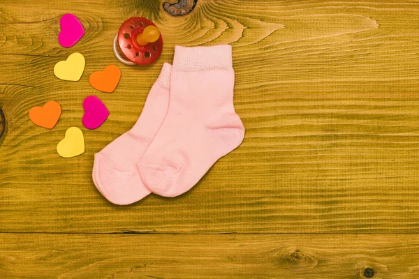 Маленькі Рожеві Дитячі Шкарпетки Соску Форми Серця Дерев Яному Столі — стокове фото