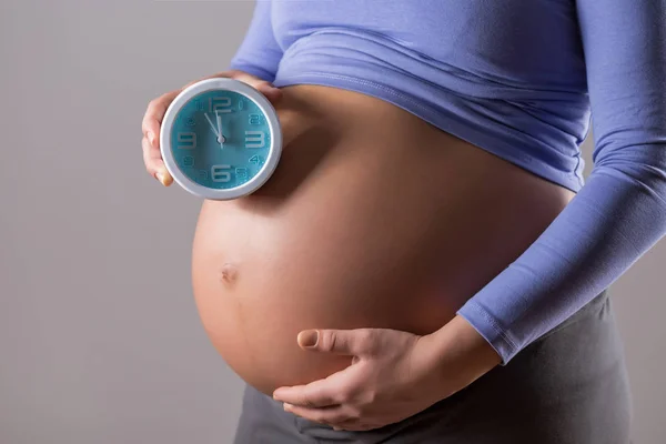 Imagen Primer Plano Del Estómago Mujer Embarazada Sosteniendo Reloj Sobre — Foto de Stock