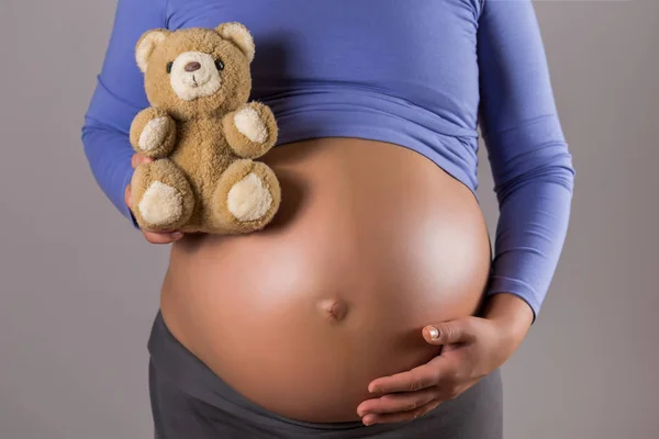 Imagen Primer Plano Estómago Mujer Embarazada Sosteniendo Osito Peluche Sobre —  Fotos de Stock