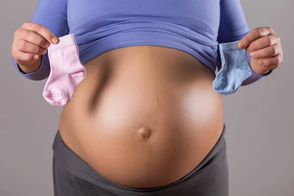 Immagine Stomaco Donna Incinta Che Tiene Calzini Rosa Blu Sfondo — Foto Stock