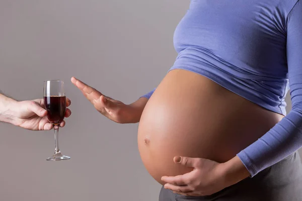 孕妇在灰色背景下拒绝饮酒的图像 — 图库照片