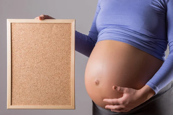 Image Close Stomach Pregnant Woman Holding Cork Board Gray Background — Stock Photo, Image