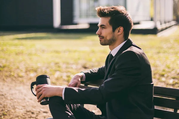 エレガントなビジネスマンは 屋外に座ってコーヒーを飲むことを楽しんでいます トーン画像 — ストック写真
