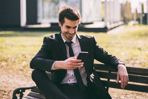 Elegant Affärsman Som Använder Telefonen Medan Sitter Utomhus Tonas Bild — Stockfoto