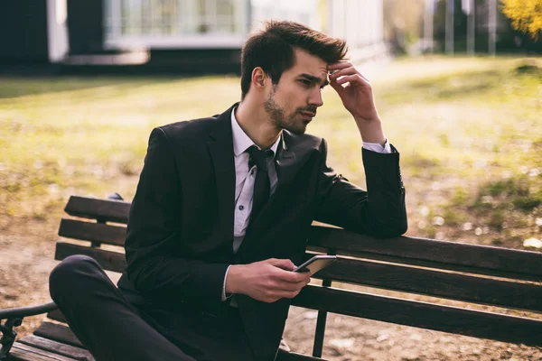 Homem Negócios Preocupado Usando Telefone Enquanto Sentado Livre Imagem Tonificada — Fotografia de Stock