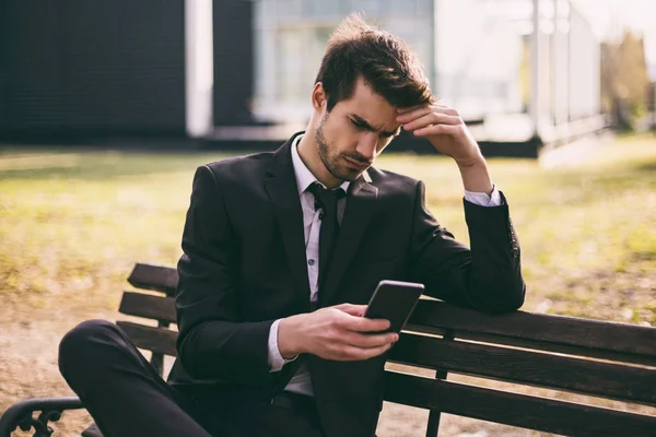 Homem Negócios Preocupado Usando Telefone Enquanto Sentado Livre Imagem Tonificada — Fotografia de Stock
