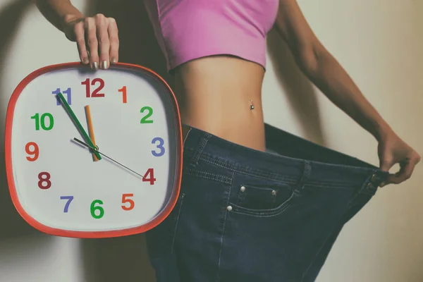 Woman Large Jeans Holding Clock Weight Loss Concept — Stock Photo, Image