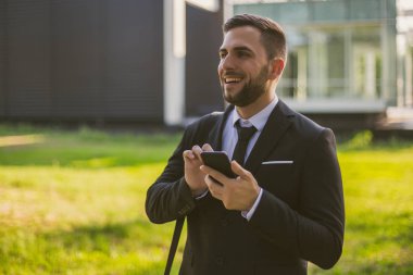 Açık havada telefon kullanan zarif bir işadamı. Tonlu fotoğraf.