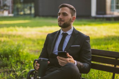 Zarif işadamı telefon kullanarak ve açık kahve içme. Tonlu fotoğraf.