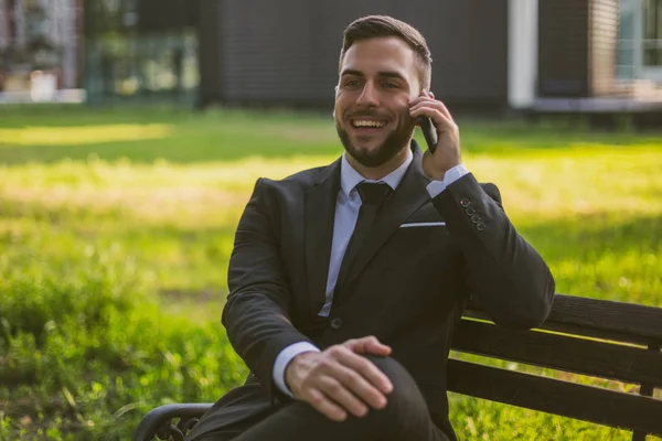屋外に座っている間 電話を使用してエレガントなビジネスマン トーン画像 — ストック写真
