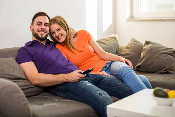 幸せなカップルは テレビを見て 自宅で一緒に時間を過ごすのを楽しみます — ストック写真