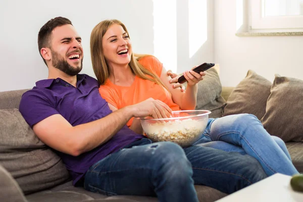 幸せなカップルは テレビを見て ポップコーンを食べて 自宅で一緒に時間を過ごすのを楽しみます — ストック写真