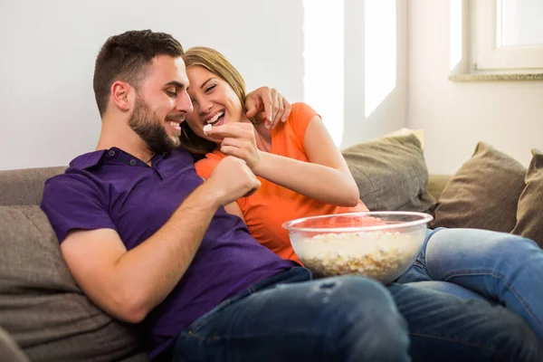 ポップコーンを食べて 彼らは彼らの家で一緒に時間を過ごすのを楽しみながら楽しむ愛のカップル — ストック写真