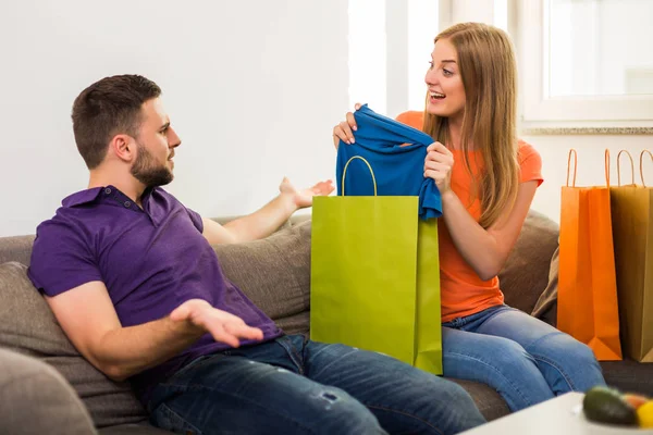 妻が自宅のソファに座っている間に買い物にお金を使いすぎたので 夫婦は対立している — ストック写真