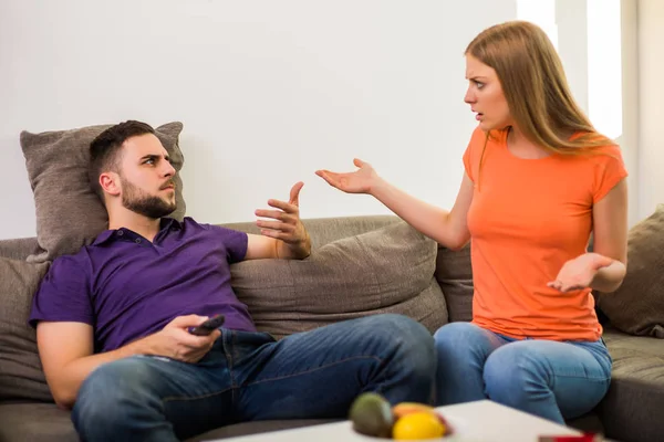 愤怒的妻子和丈夫有冲突 因为丈夫看电视太多 — 图库照片