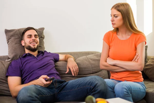 愤怒的妻子和丈夫有冲突 因为丈夫看电视太多 — 图库照片