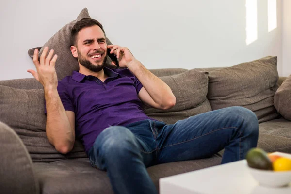 Ung Man Man Använder Mobiltelefon När Man Sitter Soffan Sitt — Stockfoto