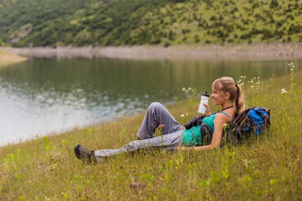 自然の中で時間を過ごしながら 水を飲む女性ハイカー — ストック写真