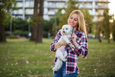 Parkta Malta köpeğini tarayan güzel bir kadın..