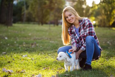 Parkta Malta köpeğini tarayan güzel bir kadın..