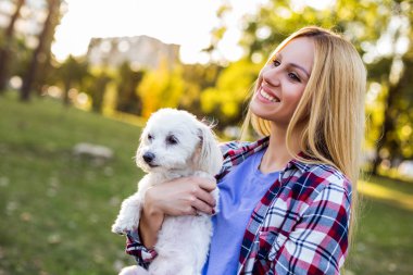 Güzel bir kadın Malta 'lı köpeğiyle dışarıda vakit geçiriyor..