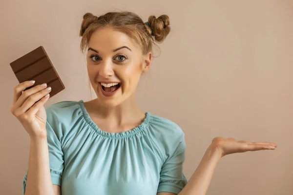 快乐可爱女人的画像喜欢吃巧克力和打手势 — 图库照片