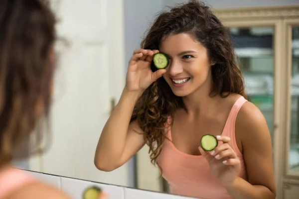 漂亮的女人在浴室里拿着几片黄瓜 — 图库照片