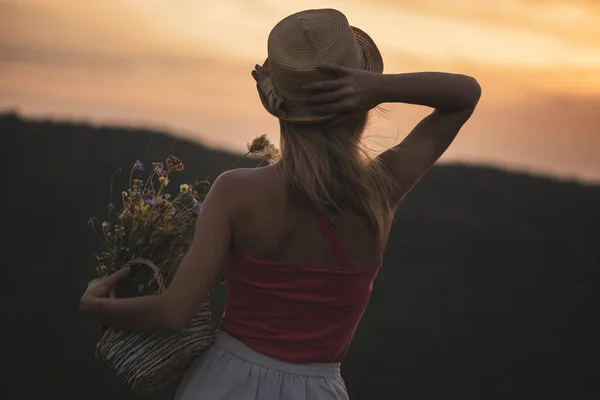 Mujer Sosteniendo Cesta Con Flores Disfruta Mirando Hermosa Puesta Sol — Foto de Stock