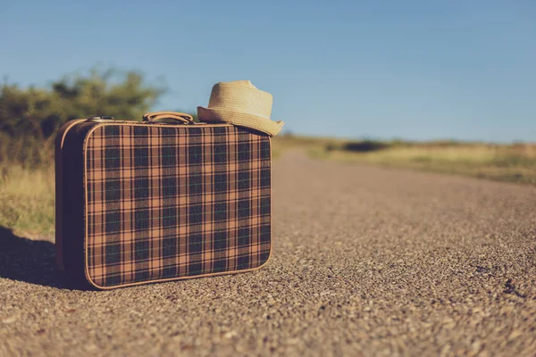 乡间路上的旧手提箱和旧帽子形象 — 图库照片