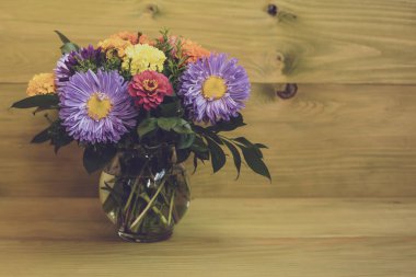 Ahşap arka planda güzel çiçekli vazo resmi.