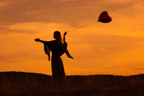 Silueta Ženy Držící Balón Tvaru Srdce Dívající Krásný Západ Slunce — Stock fotografie