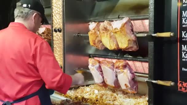Vlees is gebrand op een spit in de kerstmarkt in Hannover — Stockvideo
