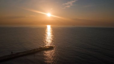 Denizde şafak. Sıcak güneş suyun üzerinde doğar. İnsansız hava aracından fotoğraflanmış. Havadan fotoğraf çekimi.