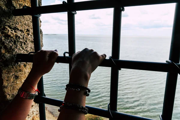 バーで女性の手と、バーの後ろに海です。囚人は海を見る. — ストック写真
