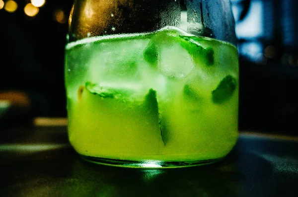 A limonada em um copo está em uma mesa de madeira. Limonada com hortelã verde . — Fotografia de Stock