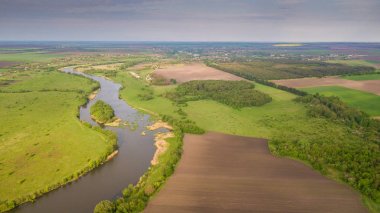 Nehir ve alanlar üst görünüm. Drone 'dan fotoğraflandı. Agropolis güzel görünümü. Bahar. Yeşil alanlar.