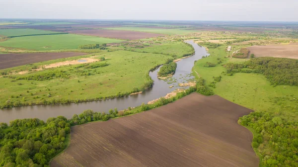 River and fields top view. Photographed from the drone. Beautiful view of the agropolis. Spring. Green fields.